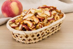 Basket of dried apple slices with fresh apple